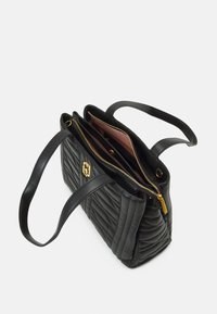 Sac fourre-tout en cuir matelassé noir avec deux anses, fermeture éclair dorée et intérieur rose. Présente un logo en accent sur l'extérieur pour un détail supplémentaire.