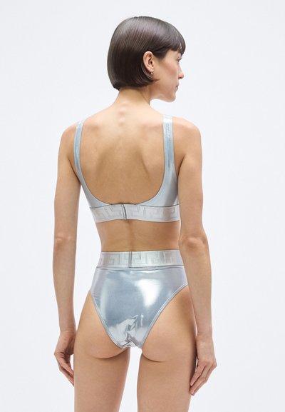 Ezüst metál színű melltartó és magas derekú alsó szett. Sima textúra, széles pántok és geometrikus minta a derékpánton. Minimalista kialakítás.