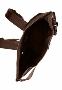 Sac à dos en tissu brun avec des sangles ajustables, un grand compartiment principal ouvert et une doublure intérieure lisse, sans quincaillerie visible.