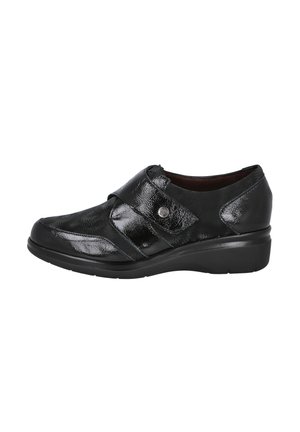 Zapato de piel negra con un acabado brillante, que presenta una correa en la parte superior, punta redondeada y un tacón bajo para mayor estabilidad y comodidad.