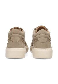 Baskets en suede de couleur neutre vues de dos, avec un profil bas et une semelle légère. Le design semble décontracté et stylé.