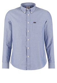 Chemise bleu clair manches longues avec des boutons, col boutonné et poche poitrine avec l’étiquette Lee sur fond blanc.