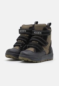 Botas de tobillo negras y verde oliva con tela texturizada, correas de velcro y suelas de goma con relieve para mayor tracción.