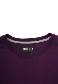 Lilla bomulds T-shirt med en grå indvendig halsudskæring. Har en rund hals og et mærke, der står "ÆRLIGHED REGNER" i hvidt på en sort baggrund.