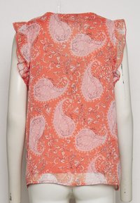 Blusa de color coral con estampado de paisley y flores, mangas cortas con volantes, tejido ligero y dobladillo redondeado. Detalles en rosa y blanco.