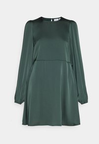 Tummanvihreä, satiininen mekko pitkillä puffihaitoilla, pyöreällä kauluksella ja hoikalla vartalolla, joka levenee vyötäröllä. Silkkinen pinta, minimaalinen yksityiskohtaisuus.