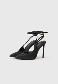 Μαύρα γόνατα με ψηλό τακούνι και μυτερή μύτη, διακοσμημένα με κρυσταλλάκια, με λεπτό λουρί στον αστράγαλο και υφή.