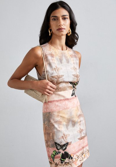 Short-sleeve dress with a photo print featuring butterflies and architectural motifs in muted pink and beige tones. Paired with a metallic clutch.