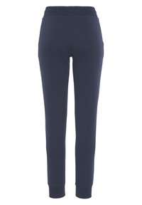 Navyfarbene Baumwoll-Sweatpants mit einem gerippten Bund, schmal zulaufenden Beinen und Seitentaschen. Glatte Textur, figurbetontes Design.