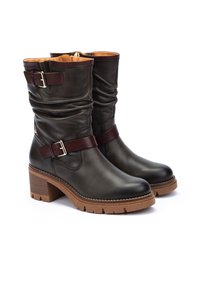Botas de tobillo de cuero marrón con un diseño arrugado, que cuentan con una correa y un acento de hebilla de cuero burdeos. Tacón de bloque grueso y suela de goma.