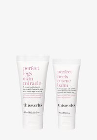 To hvide rør fra This Works: det ene mærket "Perfect Legs Skin Miracle" og det andet "Perfect Heels Rescue Balm," med pink tekst.