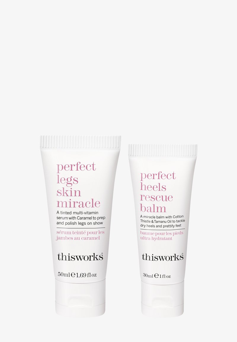 To hvide rør fra This Works: det ene mærket "Perfect Legs Skin Miracle" og det andet "Perfect Heels Rescue Balm," med pink tekst.