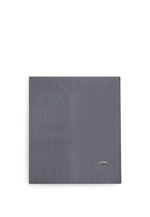 Fazzoletto di tessuto grigio piegato in piano con una trama sottile e una piccola targhetta metallica rettangolare con il logo nell'angolo in basso a destra.
