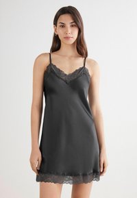 Vestido de satén negro con encaje en el escote y el dobladillo, con tirantes finos ajustables y una textura suave.