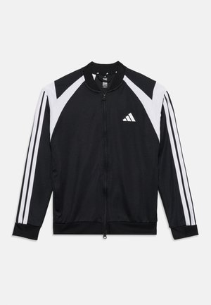 Chaqueta deportiva negra con cremallera, con paneles diagonales blancos en los hombros, tres rayas blancas en las mangas y un pequeño logo blanco en el pecho.