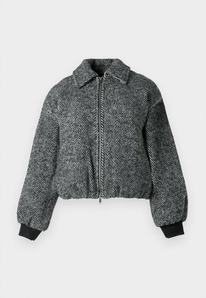 Tamsiai pilkas ir juodas žakardo paltas su apkirptu dizainu, turintis priekinį užtrauktuką, apykaklę ir banguotus rankogalius, suteikiančius tekstūrinį efektą.