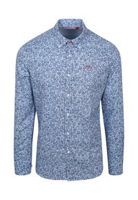 Langschedige blouse van lichtblauwe stof met intrikate bloemmotieven. Heeft een button-down kraag en een rood logo op de borst.