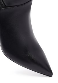 Schwarze Leder-Ankle-Boots mit spitzer Zehenpartie, die eine glatte Textur und ein elegantes Design aufweisen. Sie haben einen dezenten Glanz und eine schmale Silhouette.