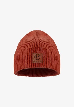 Rust-colored knit beanie with ribbed texture and a leather patch featuring "Victoria Hyde" logo on the front. Soft acrylic material.