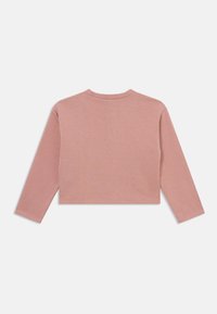 Top corto a maniche lunghe in cotone rosa chiaro. Collo rotondo con una superficie liscia, spalle senza cuciture e un design semplice.