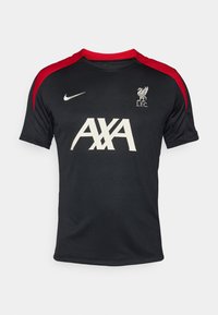 Svart Liverpool FC-tröja med röda axelaccenter, som har en vit AXA-logotyp och klubbens emblem. Tillverkad av andningsbart material med rund hals.
