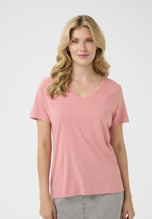 T-shirt rose à col en V en tissu doux, manches courtes, coupe décontractée, texture lisse, avec des détails de couture subtils le long de l'ourlet.