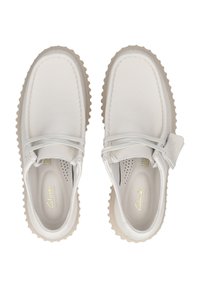 Weiße Lederschuhe mit strukturiertem Finish, runder Zehenpartie, kontrastierender beiger Gummisohle und einem geflochtenen Schnürdetail über dem Schuhoberteil.