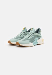Light green sneakers with mesh and smooth synthetic upper, rubber sole, padded collar, and graphic accents in contrasting colors.
