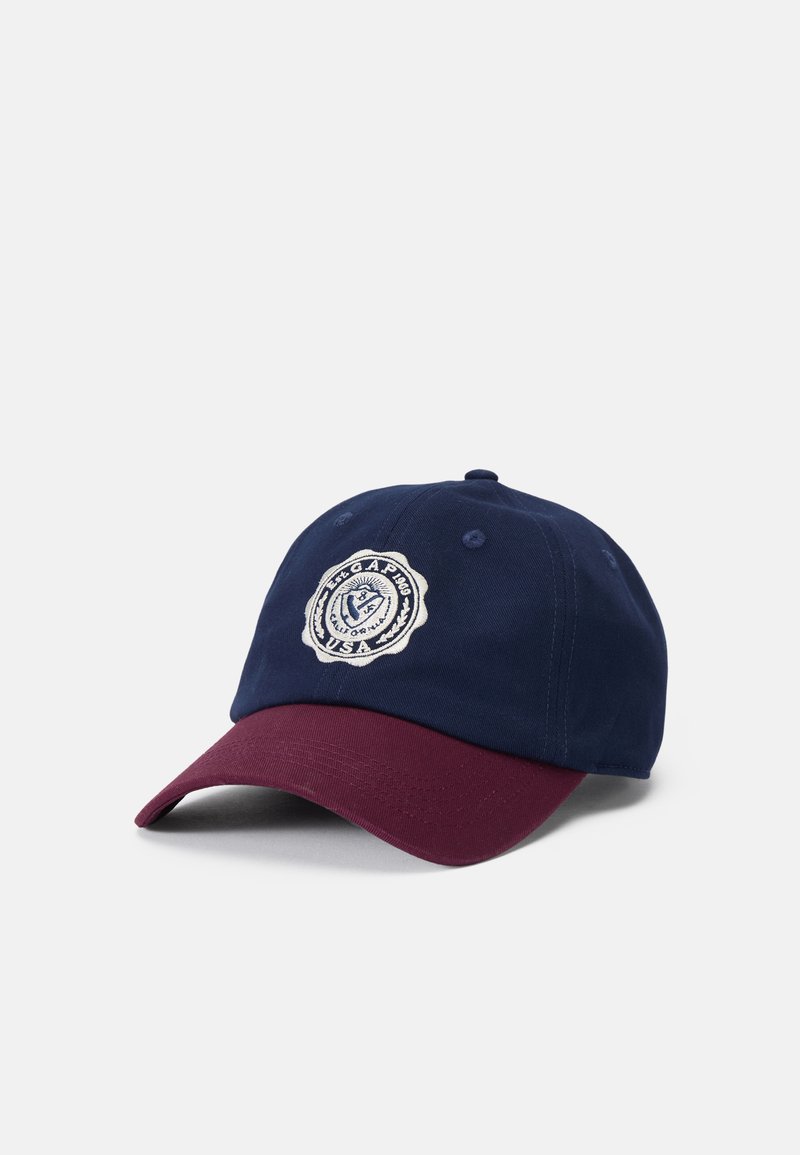 Marineblå og bordeaux baseballcap med broderet badge-detalje. Stoffet er af bomuld, med justerbar ryg, struktureret form og buet skygge.