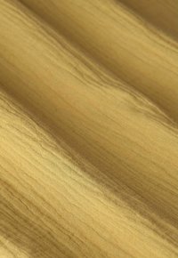 Tissu satin d'un riche ton doré, présentant une texture lisse et brillante avec de fines lignes verticales et de doux plis.