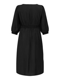 Musta mekko, joka on valmistettu kevyestä, teksturoidusta kankaasta. Mekossa on lyhyet puffihihat, smokkivyötärö ja se ulottuu polvipituuteen. Yksinkertainen ja minimalistinen muotoilu.