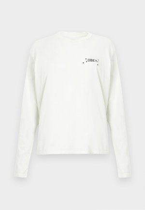 Valgete puuvillaste pika varrukaga t-särk, millel on ees vasakul rinnal trükitud tekst "OBEY" ja väikesed tähekesed.