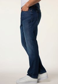 Jeans de mezclilla azul oscuro con un diseño de pierna recta, que cuentan con bolsillos frontales, detalles de costura y una cinturilla con pasadores para cinturón.