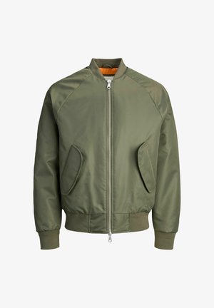 Tamsiai žalia bombinė striukė su priekiniais užtrauktukais, raglaninėmis rankovėmis, dviem šoninėmis kišenėmis ir rišamais rankogaliais. Vidaus pamušalas yra ryškiai oranžinės spalvos.