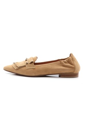 Chaussure plate en daim beige avec un bout pointu, dotée d'une frange décorative et d'accents en clous sur le dessus. Talon élastique pour un maintien sécurisé.