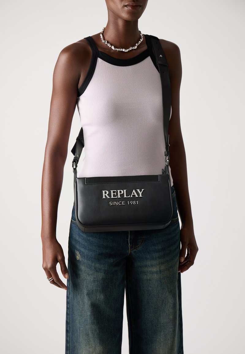 Borsa a tracolla nera in pelle con logo argentato "REPLAY SINCE 1981", texture liscia, tracolla regolabile e forma rettangolare.