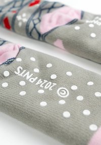 Gray socks with pink accents, featuring a dotted pattern, geometric knit design, and embossed text. Text is oriented for upward reading.