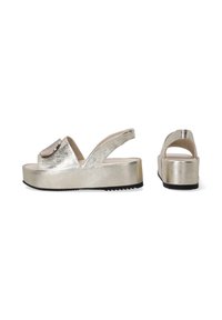 Metallisch goldene Plateau-Sandalen mit einem breiten Riemen und einem kreisförmigen Akzent an der Zehe. Die Sohle verfügt über ein strukturiertes schwarzes Traction-Muster.