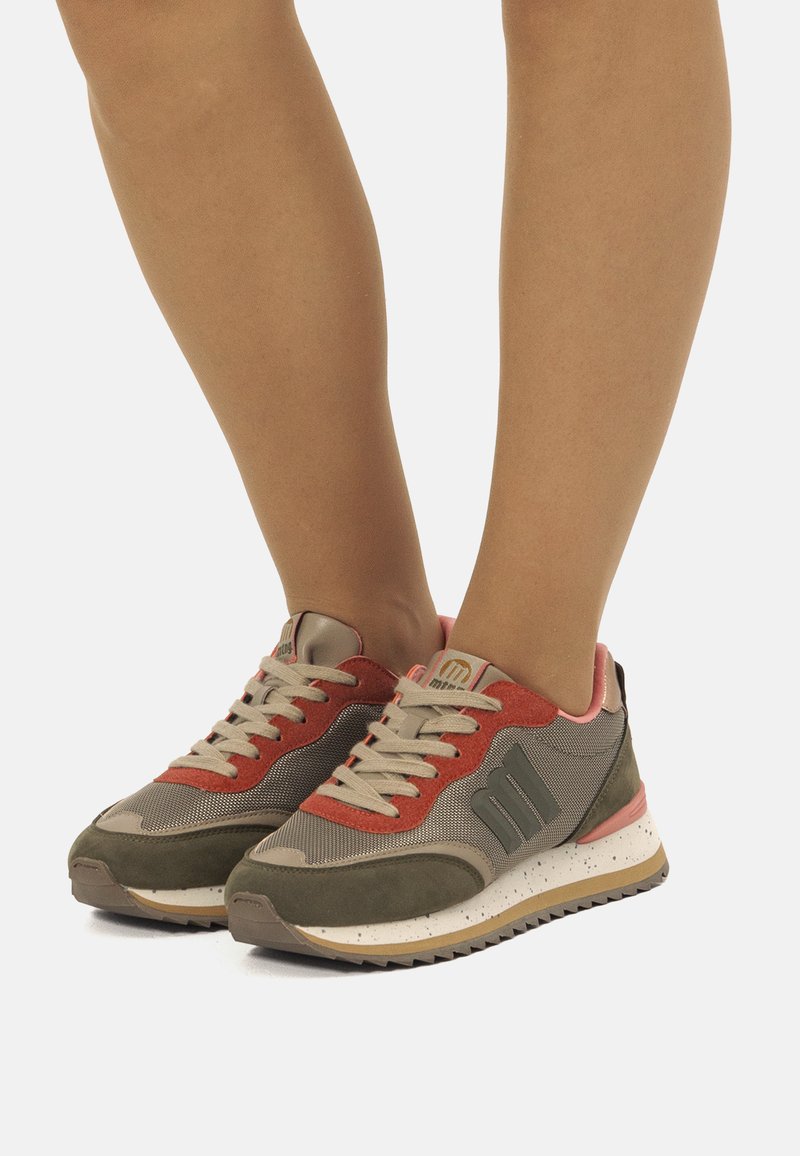 Sportliche Sneakers mit einer Mischung aus olivgrünem, rotem und beigem Material, strukturiertem Stoff, Gummisohle und Schnürdesign mit Logo-Akzenten.