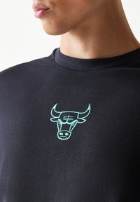 Μαύρο βαμβακερό t-shirt με κεντητό λογότυπο ταύρου σε τουρκουάζ χρώμα στο στήθος. Λαιμός με στρογγυλή λαιμόκοψη και κοντά μανίκια. Ομαλή υφή.