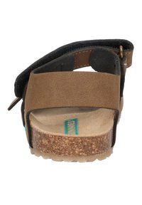 Braune Ledersandale mit schwarzen Akzenten, Korkfußbett und verstellbarem Riemen. Texturiertes Profil für besseren Halt, mit einem türkisfarbenen Logodesign.