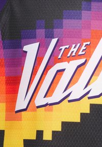 Svart sportströja med ett gradient pixelmönster i lila, orange och gult, med fet vit text som säger "THE VAL." Texten har en lätt skuggeffekt.