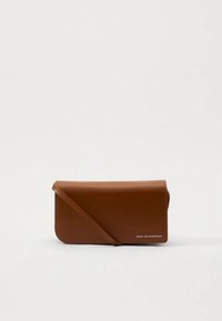 Brown leather clutch with a fold-over design, single shoulder strap, and subtle white branding. Smooth texture with no visible patterns.