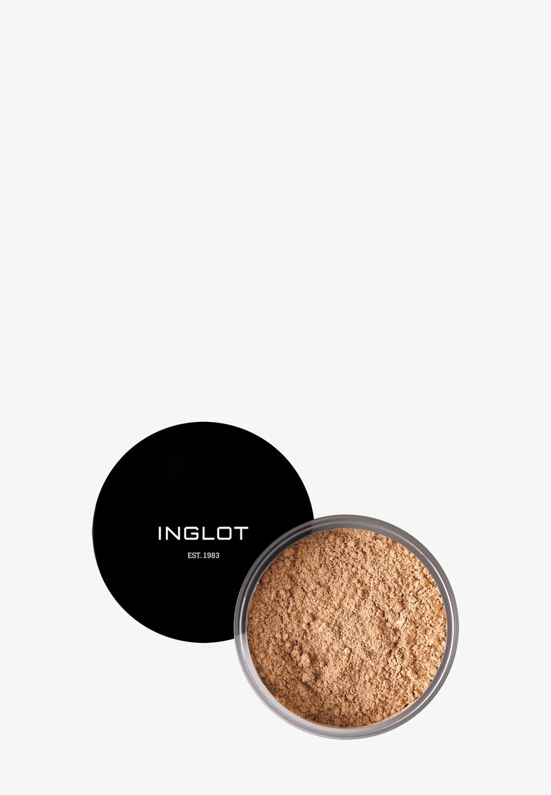 Poudre libre dans un récipient transparent avec un couvercle noir. La poudre est de couleur bronzée, à la texture fine, avec l'inscription « INGLOT EST. 1983 » affichée sur le couvercle.