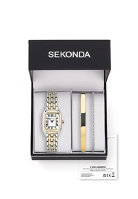 Montre en or et argent avec un cadran carré blanc, des chiffres romains noirs et un bracelet en métal bi-ton, accompagnée d'un bracelet en or et argent, le tout dans une boîte noire.