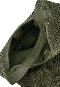 Groene geweven leren tas met een gestructureerde buitenkant, magnetische sluiting en stoffen voering met een ritsvak aan de binnenkant.