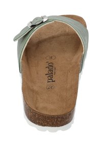 Sandalia de cuero verde con un diseño curvado, que presenta una hebilla decorativa, plantilla tipo ante y suela con textura de corcho.