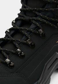 Schwarze Wanderschuhe mit strukturiertem synthetischen Obermaterial, metallischen Ösen und kontrastierenden gelb gestickten Schnürsenkeln für einen sicheren Halt.