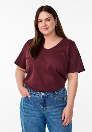 Bordeaux V-hals t-shirt gemaakt van zachte katoen met korte mouwen, gecombineerd met hoge lichtblauwe denim jeans in een klassieke fit.
