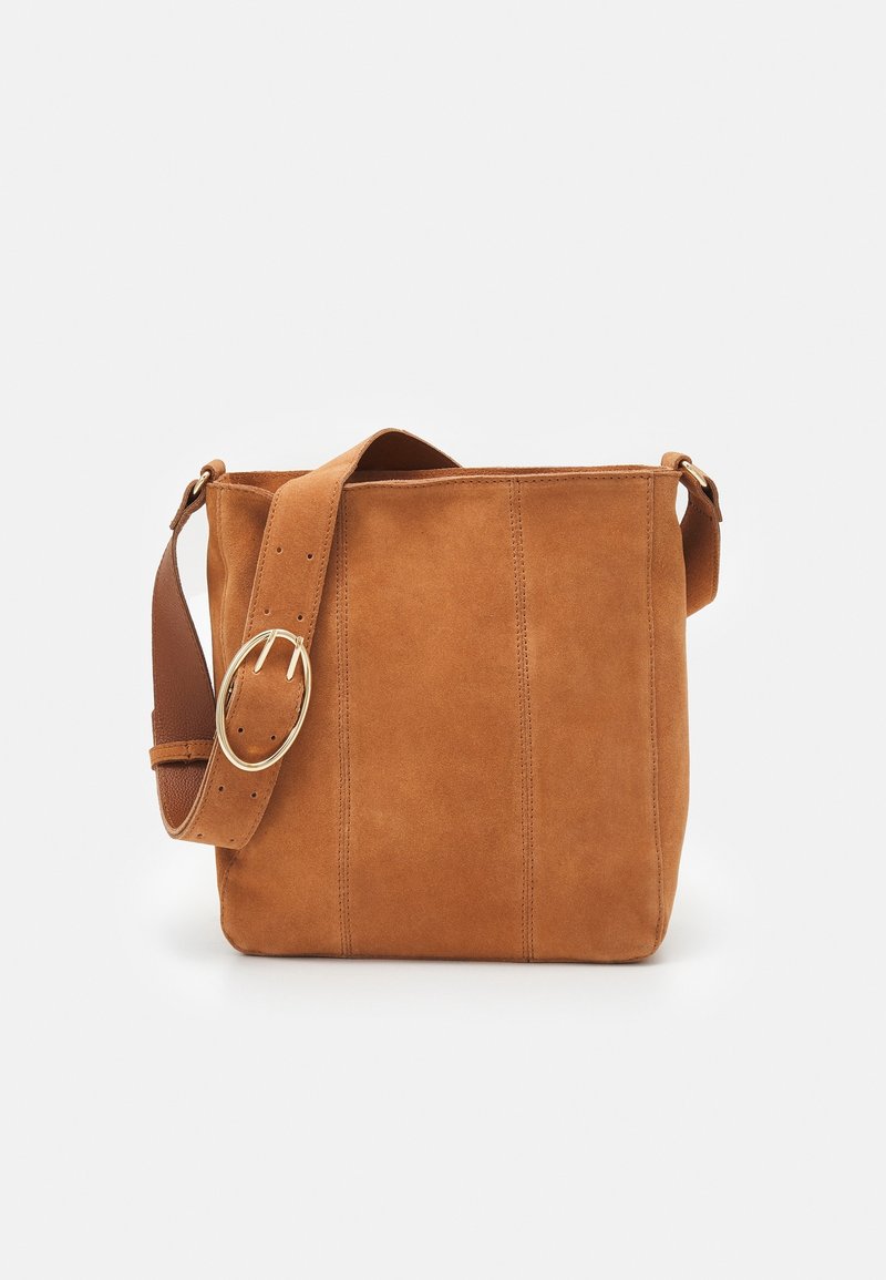 Suede håndtaske i varm tan med en glat tekstur. Har en bred, justerbar rem og en guldtonet spænde. Slank, rektangulær form.